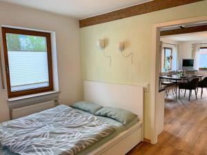 a bedroom with a bed and a dining room at Ferienwohnung am Bodensee in Singen