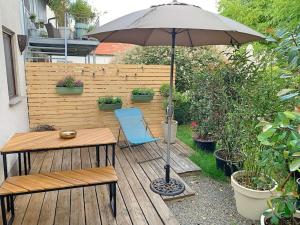 um pátio com uma mesa, um guarda-sol e uma cadeira em Ferienwohnung am Bodensee em Singen mais 4 fotografias