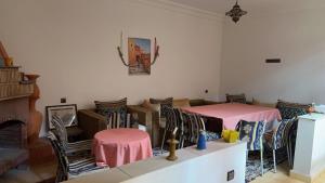 une chambre avec deux lits, des chaises et une cheminée dans l'établissement Ourika lodge the healing place, à Tafza