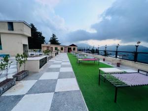 a patio with tables and benches on top of a building at Shelton's Suites Bhurban in Bhurban