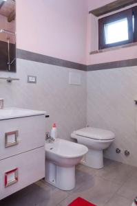 een witte badkamer met een toilet en een wastafel bij Monolocale per due Agriturismo le Pinete in Riotorto