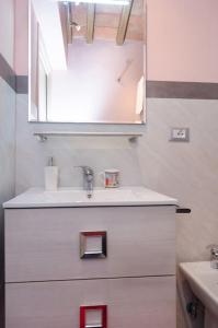 een witte badkamer met een wastafel en een spiegel bij Monolocale per due Agriturismo le Pinete in Riotorto