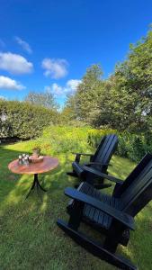 zwei Stühle und ein Tisch im Gras mit einem Tisch und zwei Stühlen in der Unterkunft Heklan in Hafnarfjördur