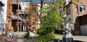a statue of a girl on a fountain in front of a building at Apartment Cottbus City - Erdgeschoss in Cottbus