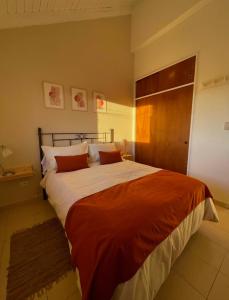 - une chambre avec un grand lit et des oreillers rouges dans l'établissement TAAR AIKE II (Lugar de Hielo), à El Calafate