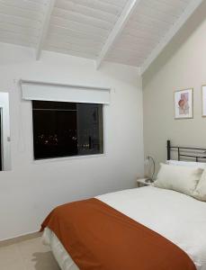 - une chambre blanche avec un lit et une fenêtre dans l'établissement TAAR AIKE II (Lugar de Hielo), à El Calafate