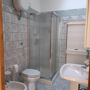Un baño con ducha, inodoro y lavabo. en Casa Vacanze Maria, en Cursi