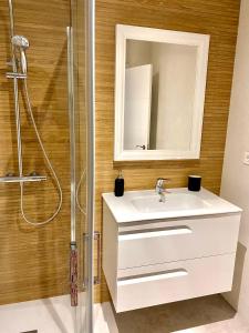 ein Badezimmer mit einem weißen Waschbecken und einem Spiegel in der Unterkunft Apartamento Luz de Conil. WIFI+A/C. SOLO FAMILIAS Y PAREJAS in Conil de la Frontera