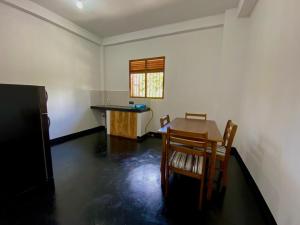 a room with a table and chairs and a kitchen at Home Stay Polhena in Matara