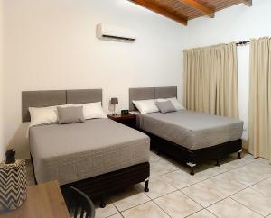 a bedroom with two beds and a table and a table sidx sidx sidx at Helechos Hotel in Comayagua