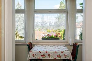 une table dans une pièce avec une fenêtre et une nappe dans l'établissement Villa Regina Fürstensuite, à Friedrichroda