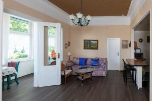 a living room with a couch and a table at Villa Regina Fürstensuite in Friedrichroda