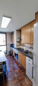 a kitchen with wooden cabinets and a tile floor at Pirineo Aragonés in Latas