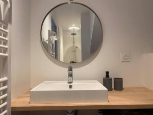 een badkamer met een witte wastafel en een spiegel bij #Le Jaurès - Studio à la Gare - Neuf et Lumineux in Brive-la-Gaillarde