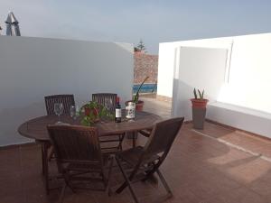a wooden table with chairs and wine glasses on a patio at Casa tomas C in Villaverde +4 photos