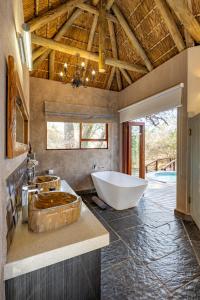 a large bathroom with a tub and a sink at Kusudalweni Safari Lodge & Spa in Guernsey Nature Reserve