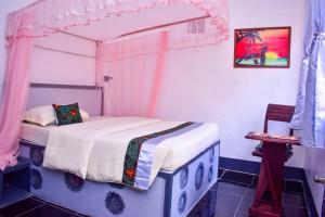 ein Schlafzimmer mit einem Himmelbett in der Unterkunft Citizen Cafe & Chambers in Mbale