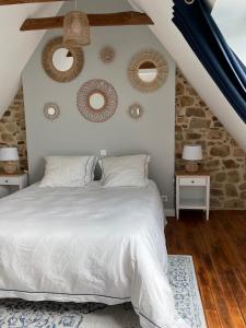 um quarto com uma cama branca e duas mesas em Les Cottages du Manoir, Jacuzzi -Crozon em Crozon