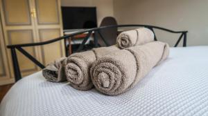una pila de toallas sentadas encima de una cama en Cozy double room - Only room, en Londres