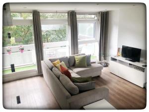 uma sala de estar com um sofá e uma grande janela em Authentic Battersea Experience em Londres