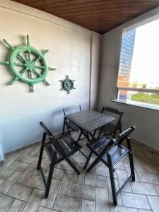 a table and chairs in a room with a boat on the wall at Apto Praia Mariscal in Bombinhas