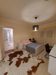 a bedroom with a bed and a room with a rug at Duplex villa in 6th Of October