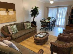 a living room with a couch and chairs and a table at Apto Praia Mariscal in Bombinhas