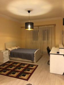 a bedroom with a bed and a desk and a lamp at Duplex villa in 6th Of October