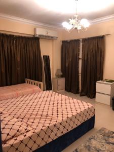 a bedroom with two beds and a chandelier at Duplex villa in 6th Of October