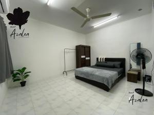 een slaapkamer met een bed en een plafondventilator bij Homestay Azalea in Cukai