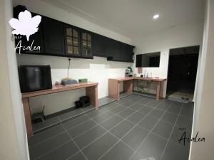 a kitchen with black cabinets and a tiled floor at Homestay Azalea in Cukai +7 photos
