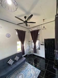 salon z kanapą i wentylatorem sufitowym w obiekcie Abe cottage w mieście Kuala Besut