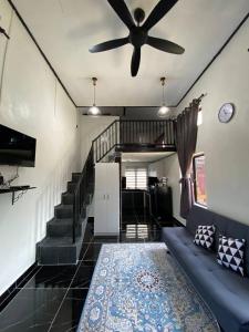 un soggiorno con ventilatore a soffitto e divano di Abe cottage a Kampung Kuala Besut