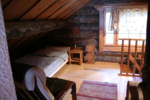 a attic room with a bed and a window at Kelola Cottage in Keyritty