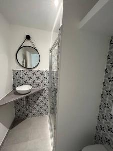 La salle de bains est pourvue d'une douche, d'un lavabo et d'un miroir. dans l'établissement La Galerie de Lumière 201, à Aurillac
