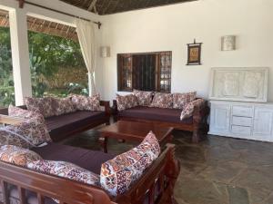 a living room with couches and a table at Lion Garden Villa 6 in Malindi