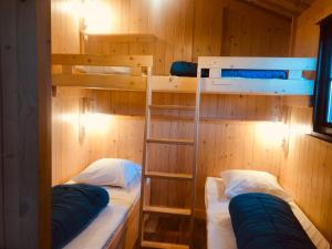 Lodges du Camping les 4 Saisons في Grane: غرفة بسريرين بطابقين في كابينة