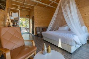 a bedroom with a bed with a mosquito net at แคมป์ต๊ะต่อนยอน แม่กำปอง เชียงใหม่ CAMP Ta-Torn-Yorn Maekampong Chiang Mai in Mae On +117 photos