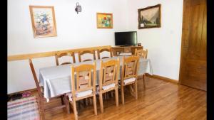 comedor con mesa, sillas y TV en Casa dintre Brazi, en Arieşeni