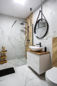 a bathroom with a sink and a glass shower at Apartament Parkowy przy Stadionie Śląskim Katowice Chorzów in Chorzów