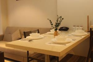 a table with plates and cups and a vase of flowers at Tambuli maribago residence condominium in Maribago