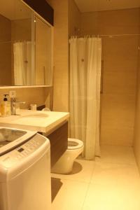 a bathroom with a toilet and a sink and a shower at Tambuli maribago residence condominium in Maribago