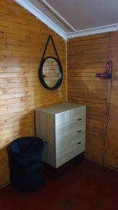a room with a dresser and a mirror and a trash can at Mike's Lodge Sodwana Bay in Sodwana Bay