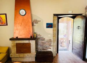 a living room with a fireplace and a clock on the wall at Appartamento in casale rustico - La Masseria in Busso