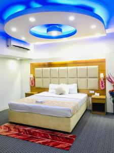 a bedroom with a large bed with a blue ceiling at Grand Plaza Hotel in Dhaka