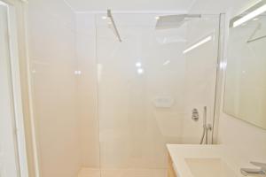 Un baño blanco con ducha y lavabo. en Luxury sea front suite Promenade, en Niza