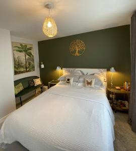 una camera da letto con un grande letto bianco con una parete verde di No 12 B&B a Dungarvan