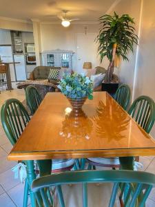 a wooden table with a vase of flowers on it at Apto Praia Mariscal in Bombinhas