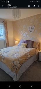 a bedroom with a large bed with a floral wallpaper at Hillend Self-Catering in Portree