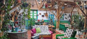 a room filled with lots of furniture and plants at Hostel Camelot Salento in Salento